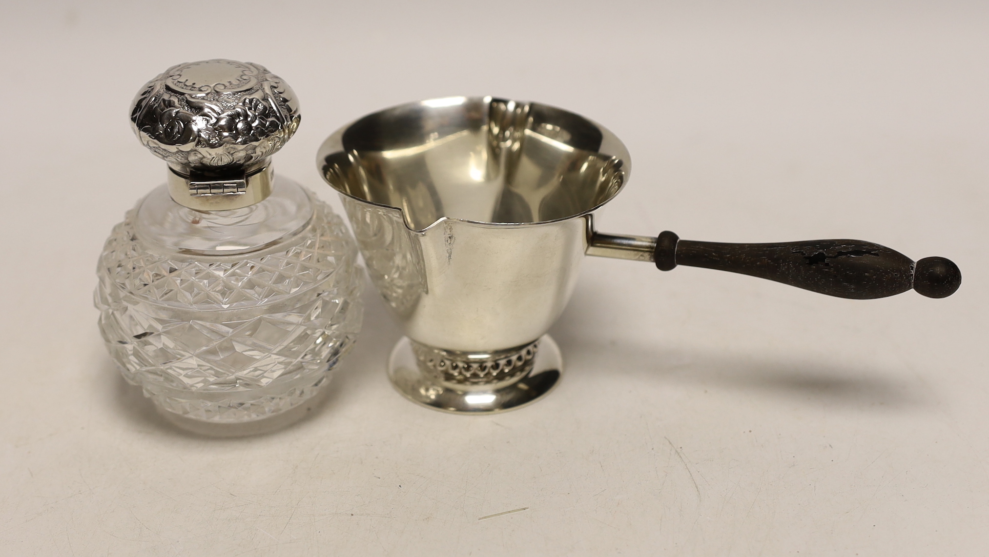 A sterling double lipped pan with turned wooden handle, 17.5cm and a modern silver mounted cut glass scent bottle.